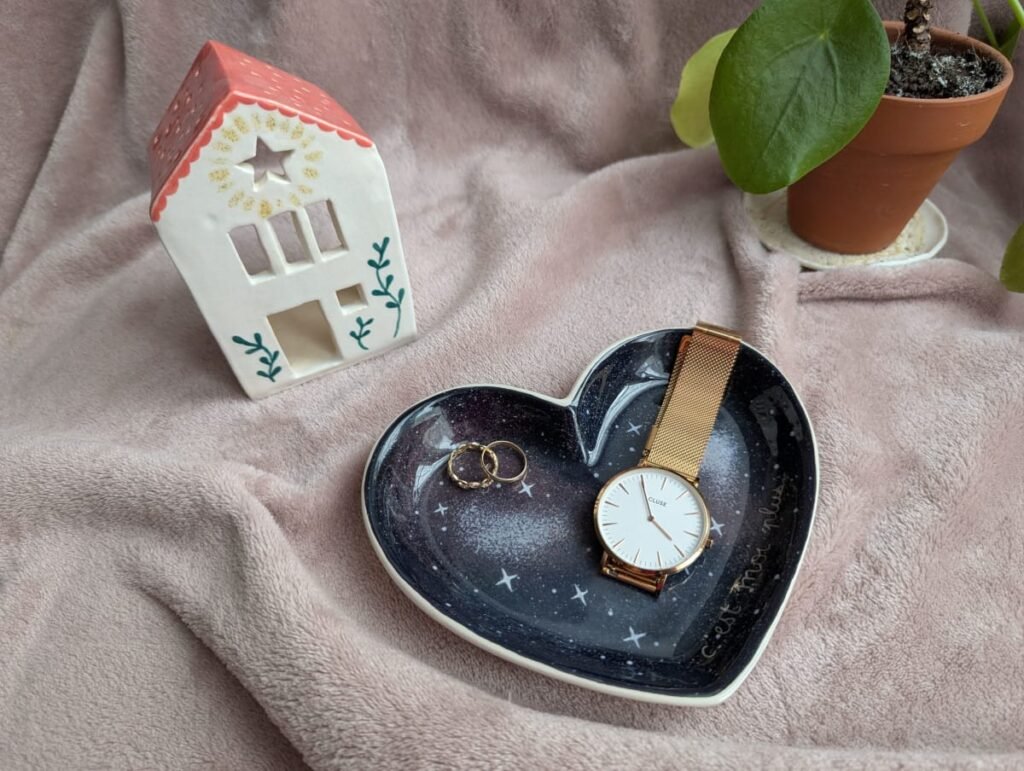 Vide poche en céramique peint à la main, motif galaxie, mise en situation avec des éléments de décoration, montre et bagues